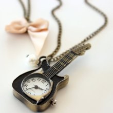 A beautiful antique bronze guitar pocket watch with a satin bow and a mother of pearl