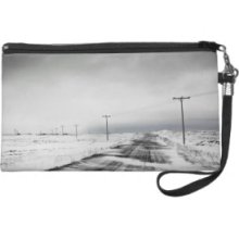 Telephone poles in snow covered field Wristlet Purses